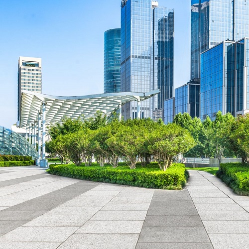 A Picture of an Empty Pavement in Front of Modern Architecture.