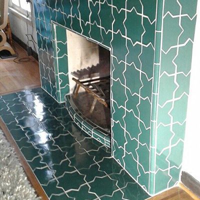 A Picture of a Fireplace with Green Tile.